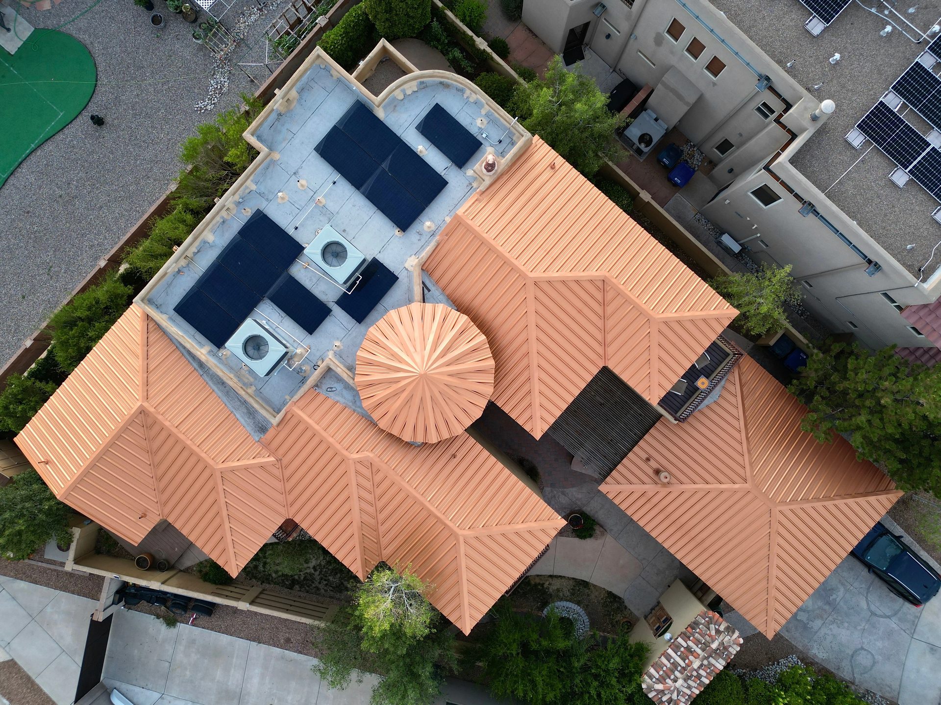 Aerial view of a multi-level New Mexico home with a copper standing-seam metal roof installed by Toro Construction