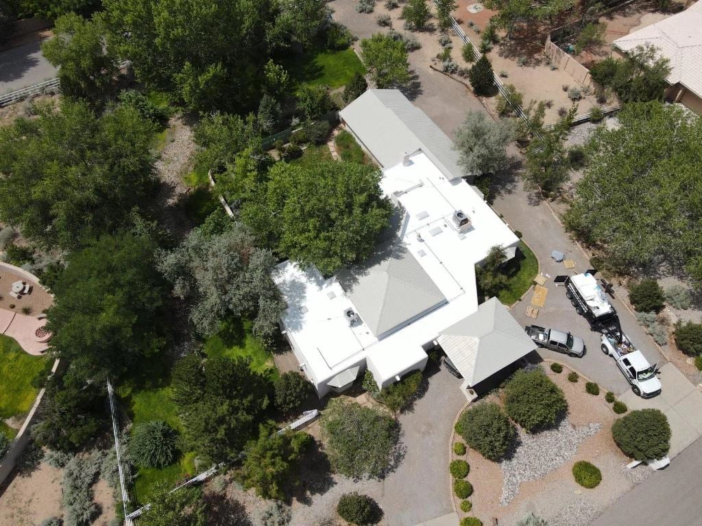 Aerial view of a finished roof on a home surrounded by trees