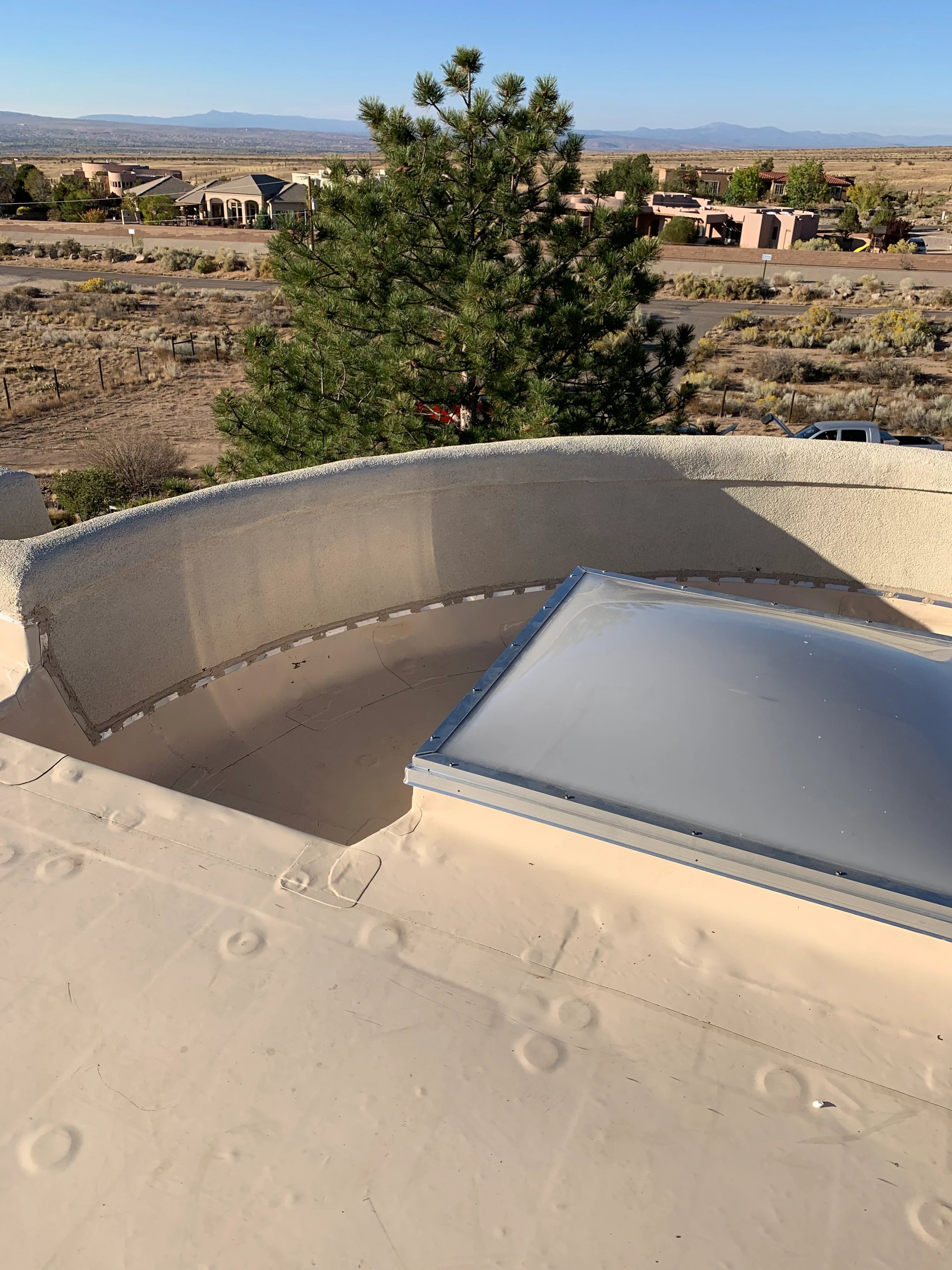 Flat foam roof with a curved parapet in the high desert
