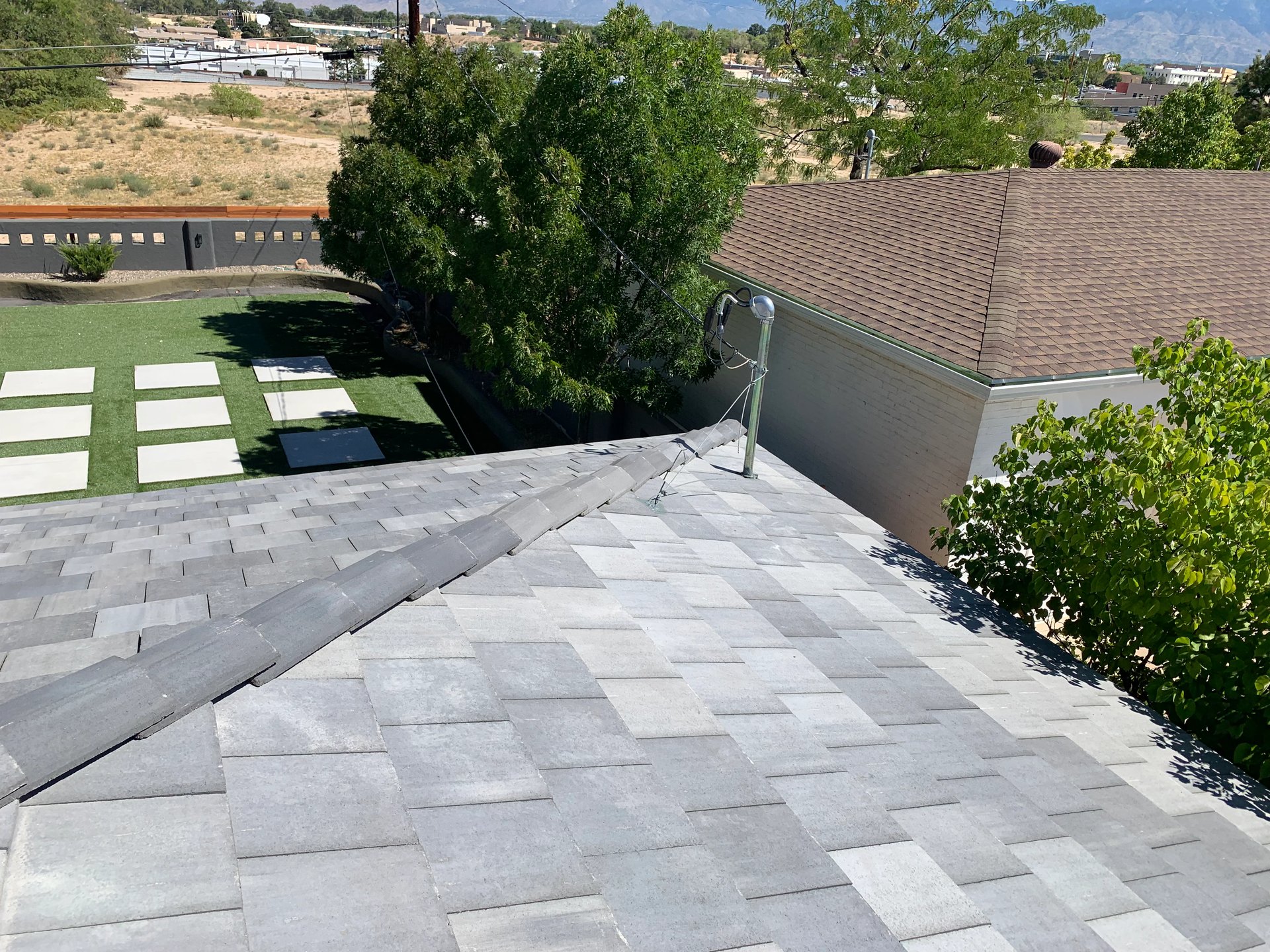 New grey asphalt shingle roof with mountains in the distance