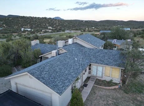 Aerial view of a new grey asphalt shingle roof on a high-desert home