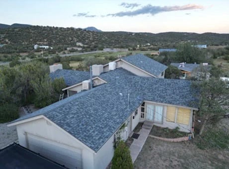 Aerial view of a new grey asphalt shingle roof on a high-desert home
